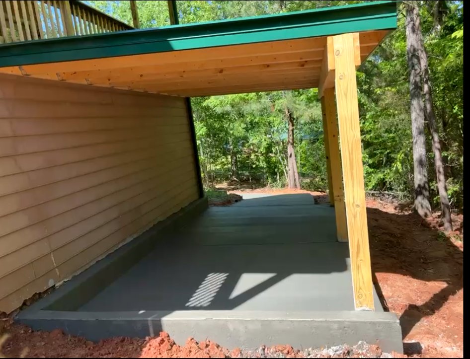 A clean, finished concrete slab beneath a covered carport.